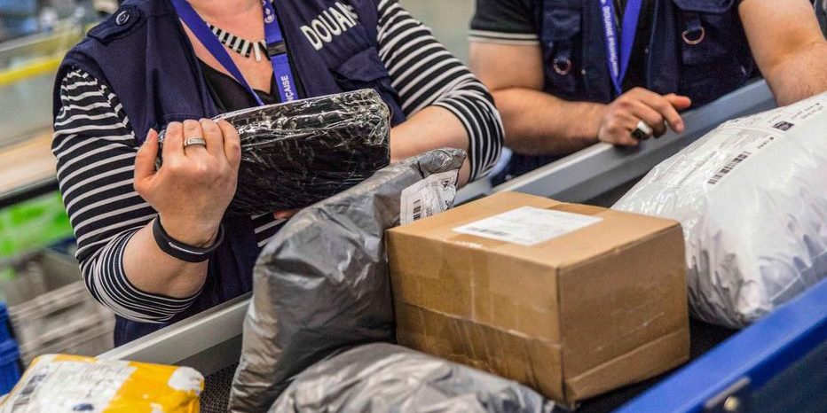 Des agents des douanes de l’aéroport de Roissy-Charles de Gaulle contrôlent des paquets postaux venant d’être déchargés d’avion en provenance de l’étranger. Simon LAMBERT/HAYTHAM-REA