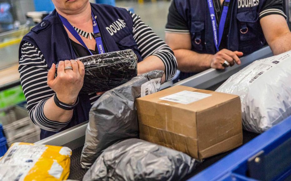 Des agents des douanes de l’aéroport de Roissy-Charles de Gaulle contrôlent des paquets postaux venant d’être déchargés d’avion en provenance de l’étranger. Simon LAMBERT/HAYTHAM-REA